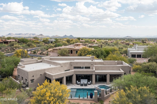 aerial view of property and surrounding area featuring mountains and a pool area