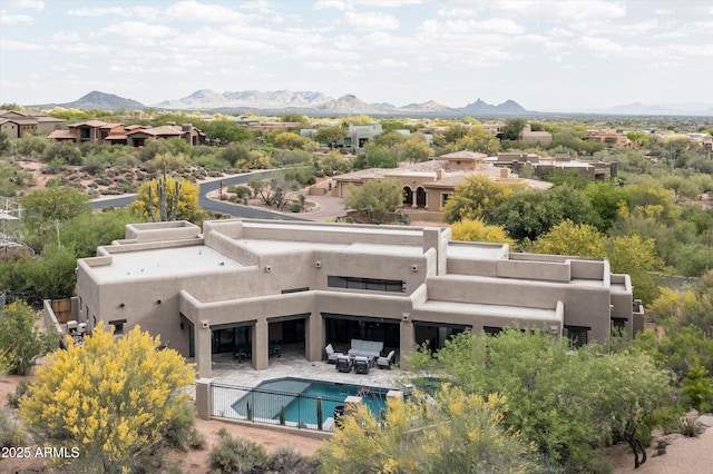 back of property featuring a mountain view, stucco siding, and a patio