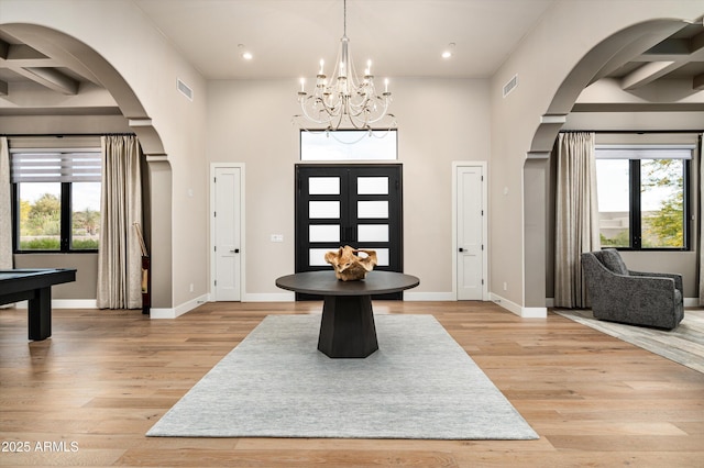entrance foyer with arched walkways, light wood-style floors, baseboards, and recessed lighting