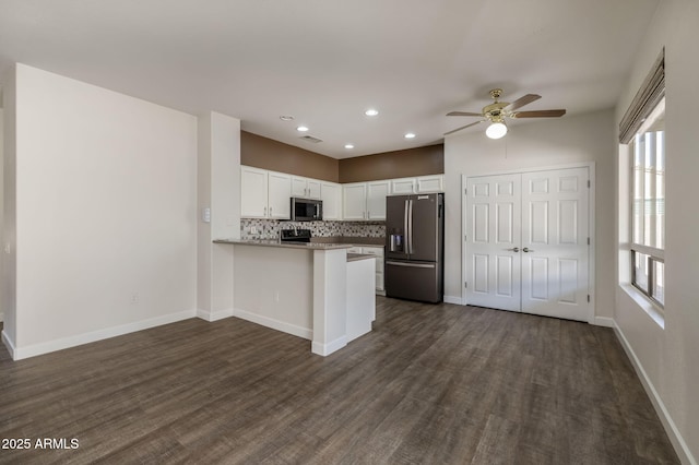 kitchen with kitchen peninsula, dark hardwood / wood-style flooring, stainless steel appliances, ceiling fan, and white cabinets