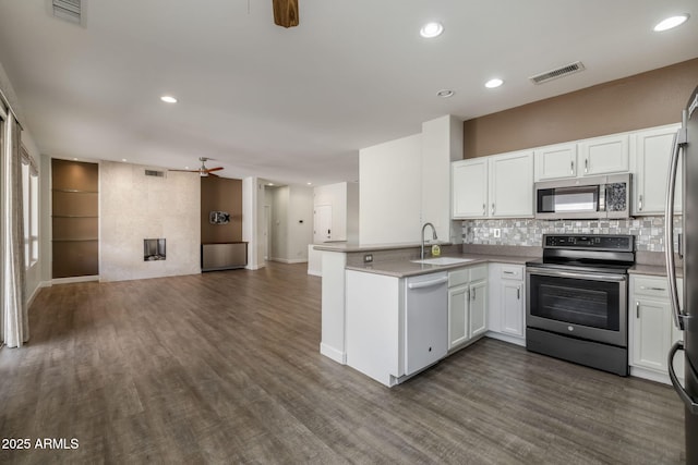 kitchen featuring kitchen peninsula, stainless steel appliances, white cabinetry, and ceiling fan