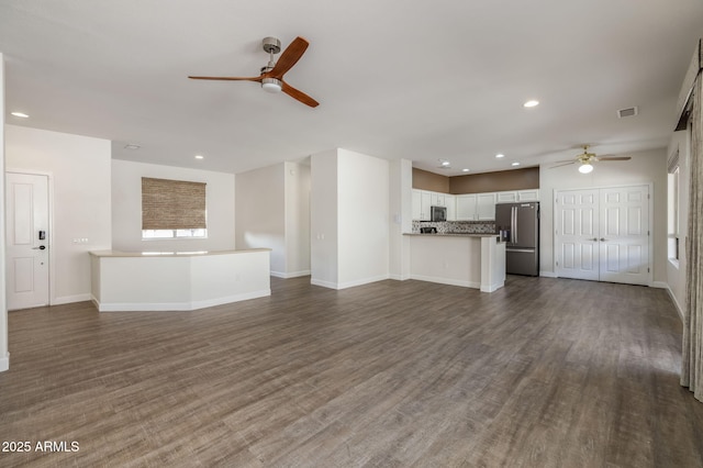 unfurnished living room with ceiling fan and dark hardwood / wood-style flooring