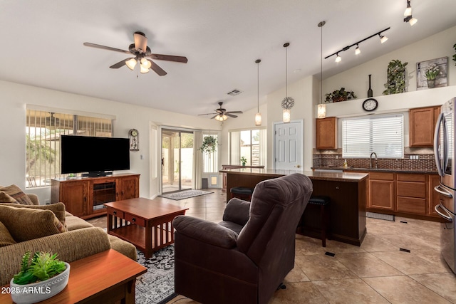 11318 S Hopi Dr, Goodyear, AZ 85338 - living room with ceiling fan, lofted ceiling, rail lighting, and light tile patterned floors