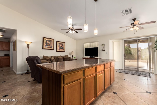 11318 S Hopi Dr, Goodyear, AZ 85338 - kitchen with ceiling fan, lofted ceiling, open floor plan, light tile patterned floors, and dark stone counters