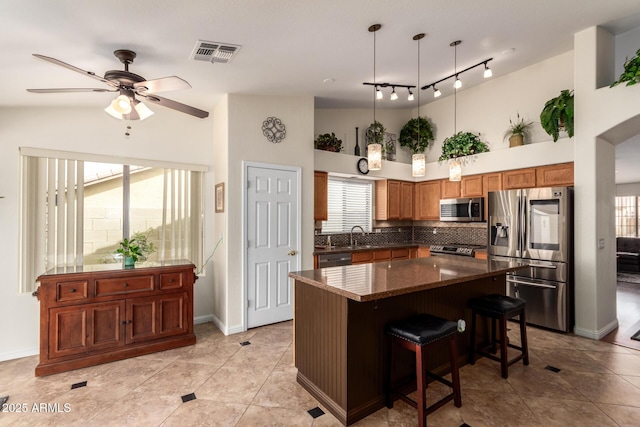 11318 S Hopi Dr, Goodyear, AZ 85338 - kitchen with appliances with stainless steel finishes, ceiling fan, healthy amount of natural light, tasteful backsplash, and a towering ceiling