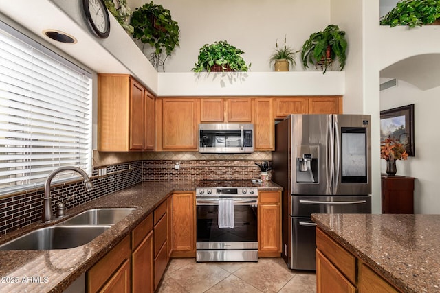 11318 S Hopi Dr, Goodyear, AZ 85338 - kitchen with appliances with stainless steel finishes, a sink, backsplash, and dark stone countertops