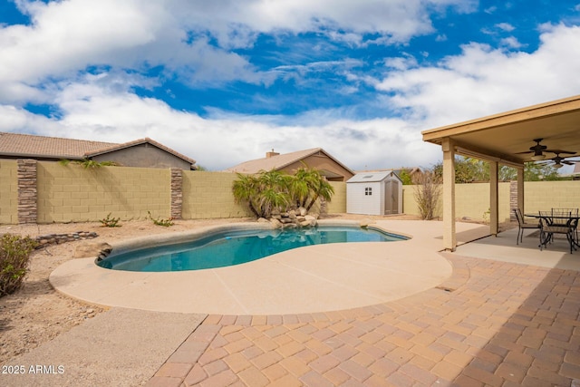 11318 S Hopi Dr, Goodyear, AZ 85338 - view of swimming pool featuring a storage unit, a patio, a fenced backyard, a ceiling fan, and an outbuilding