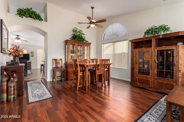 11318 S Hopi Dr, Goodyear, AZ 85338 - dining room with a ceiling fan, wood finished floors, arched walkways, and a towering ceiling