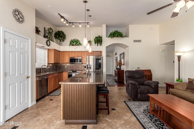 11318 S Hopi Dr, Goodyear, AZ 85338 - kitchen with stainless steel appliances, open floor plan, ceiling fan, a breakfast bar, and a high ceiling