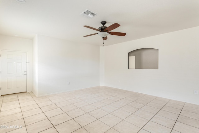 empty room with light tile patterned floors, visible vents, and a ceiling fan