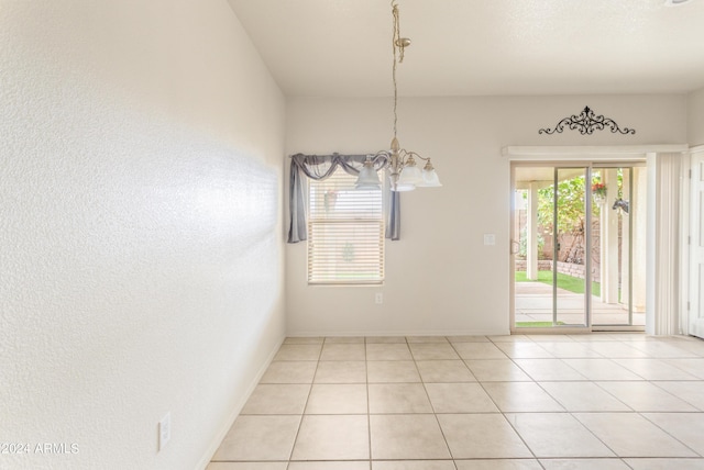 unfurnished room with a notable chandelier, plenty of natural light, and light tile patterned flooring