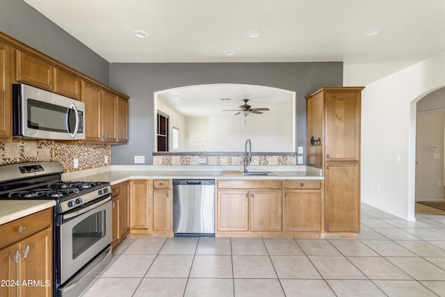 kitchen featuring a sink, appliances with stainless steel finishes, light tile patterned floors, and light countertops