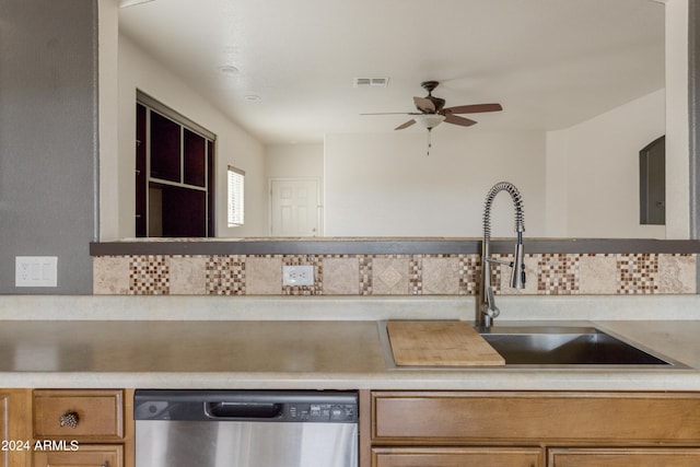 kitchen featuring visible vents, a sink, backsplash, light countertops, and dishwasher