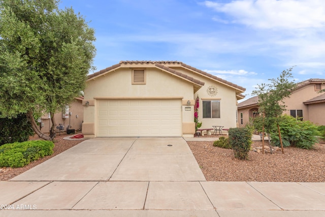 view of front of home with a tiled roof, stucco siding, driveway, and an attached garage