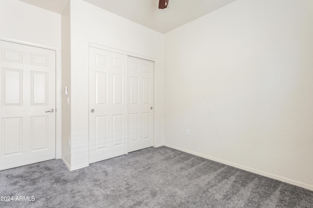 unfurnished bedroom featuring carpet flooring, baseboards, a closet, and ceiling fan