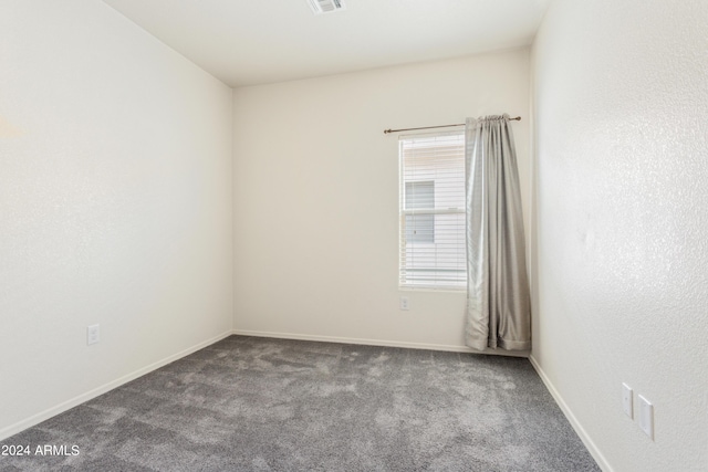 carpeted spare room featuring visible vents and baseboards