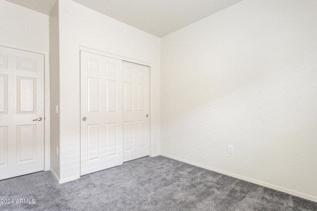 unfurnished bedroom with a closet, baseboards, and carpet