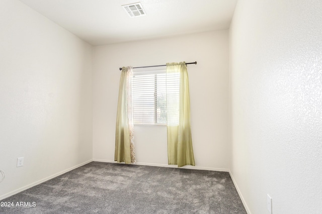 carpeted spare room featuring visible vents and baseboards