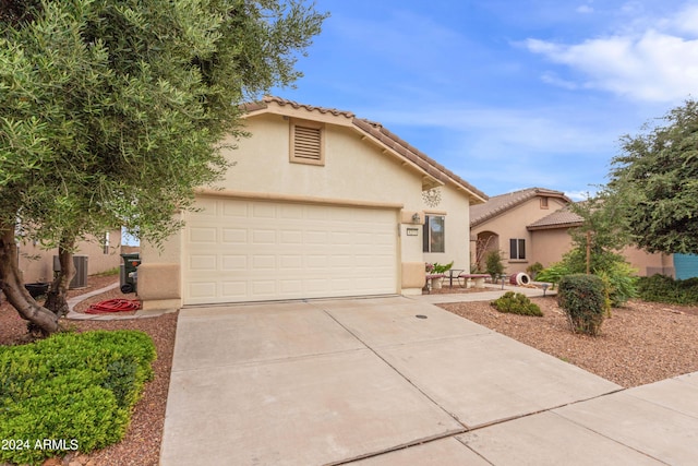 mediterranean / spanish-style house with stucco siding, a tiled roof, concrete driveway, and a garage