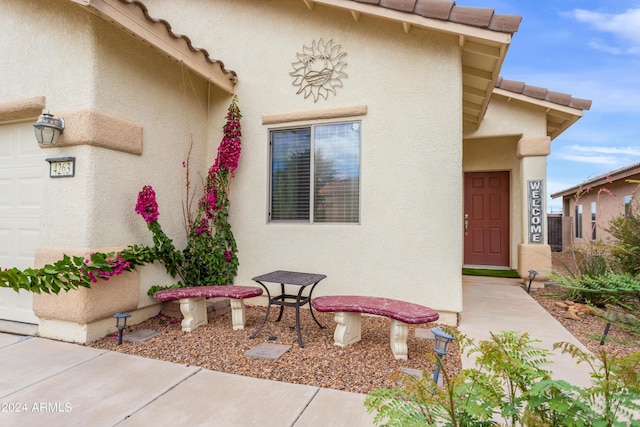 entrance to property featuring a tile roof and stucco siding