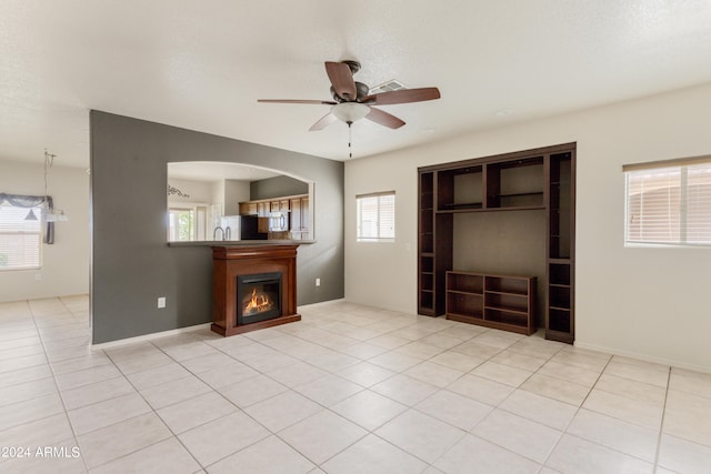 tiled bedroom featuring multiple windows, refrigerator, ceiling fan, and a closet