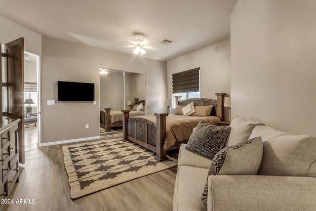 bedroom with a closet, light hardwood / wood-style floors, and ceiling fan