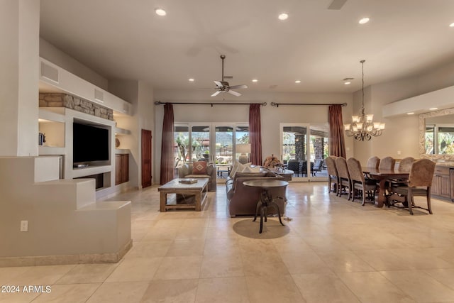 living room with ceiling fan with notable chandelier and light tile floors