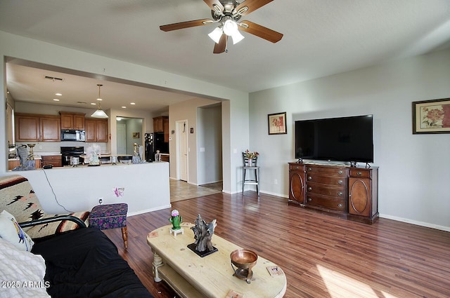 living room featuring ceiling fan and hardwood / wood-style floors