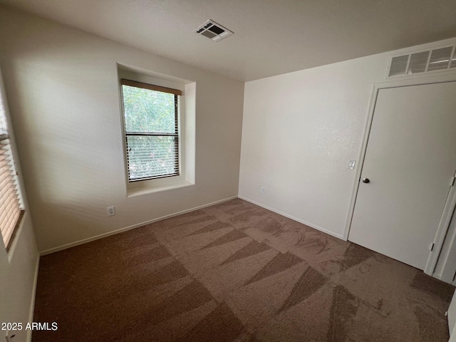 carpeted empty room featuring baseboards