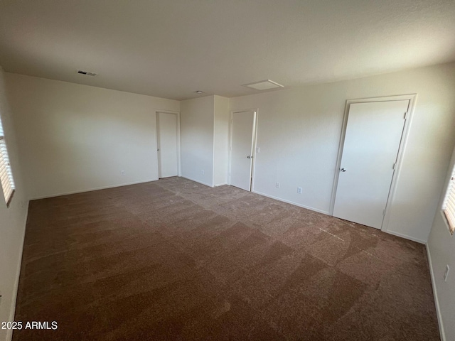 carpeted empty room featuring baseboards