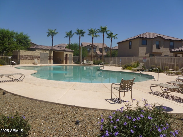 community pool featuring fence and a patio