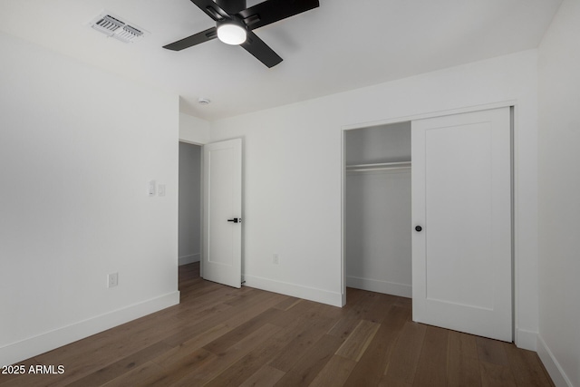 unfurnished bedroom featuring a closet, ceiling fan, and dark wood-type flooring