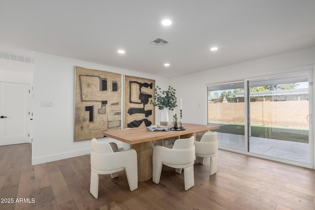 dining space with wood-type flooring