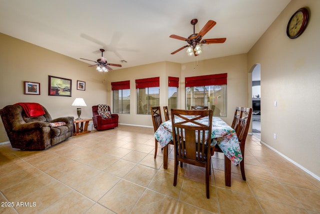 10242 E Pantera Ave, Mesa, AZ 85212 - dining room with arched walkways, light tile patterned floors, ceiling fan, and baseboards