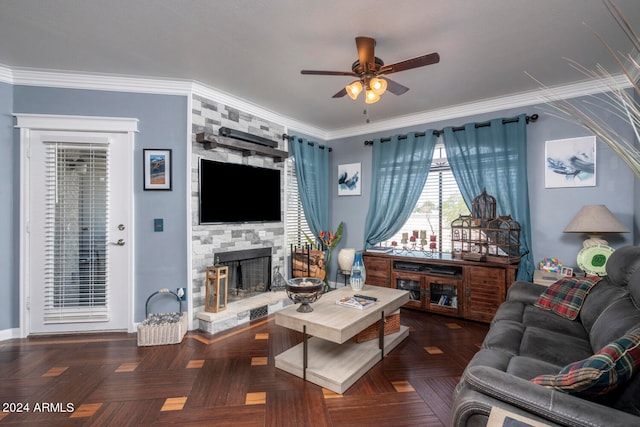 living room with ceiling fan, a fireplace, crown molding, and dark parquet floors