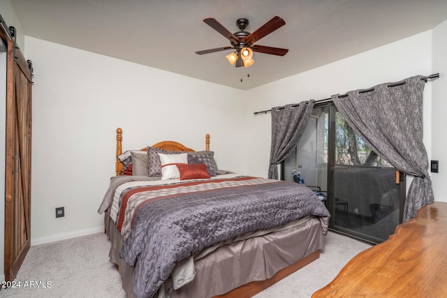 carpeted bedroom featuring ceiling fan and a barn door