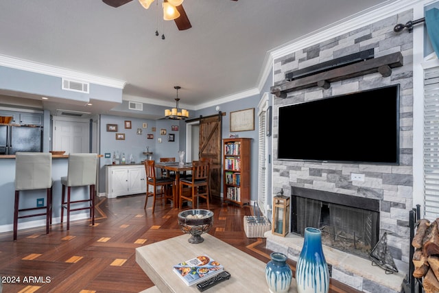 living room with ceiling fan, a fireplace, a barn door, ornamental molding, and dark parquet floors