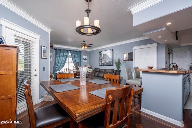 dining space featuring ceiling fan with notable chandelier, dark hardwood / wood-style flooring, and crown molding