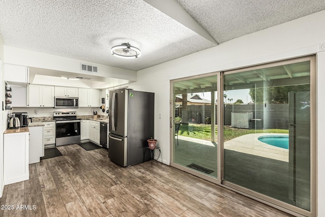 18818 N 12th Ave, Phoenix, AZ 85027 - kitchen featuring appliances with stainless steel finishes, white cabinets, dark wood-style floors, a textured ceiling, and light countertops