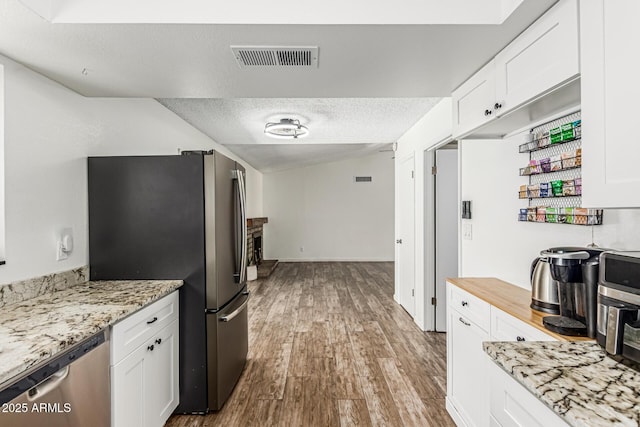 18818 N 12th Ave, Phoenix, AZ 85027 - kitchen with appliances with stainless steel finishes, white cabinetry, a textured ceiling, and wood finished floors