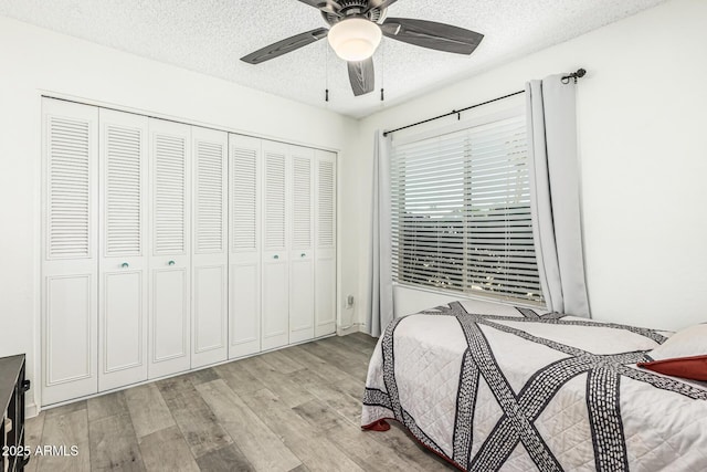 18818 N 12th Ave, Phoenix, AZ 85027 - bedroom with light wood-type flooring, a textured ceiling, a closet, and ceiling fan