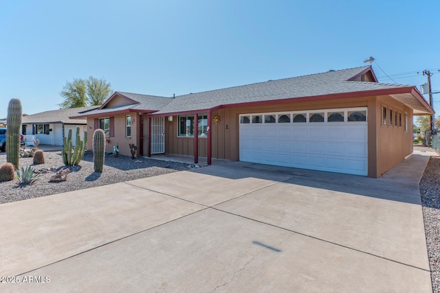 ranch-style home with an attached garage, board and batten siding, driveway, and a shingled roof