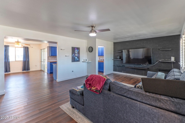 living area with dark wood finished floors, baseboards, and ceiling fan