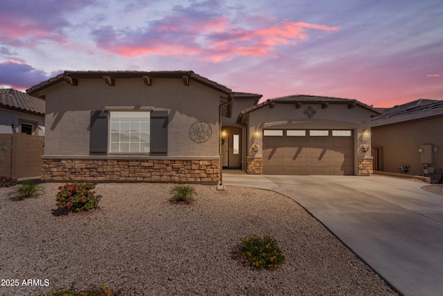 18916 W Laurel Ln, Surprise, AZ 85388 - mediterranean / spanish home featuring stone siding, concrete driveway, stucco siding, and a garage