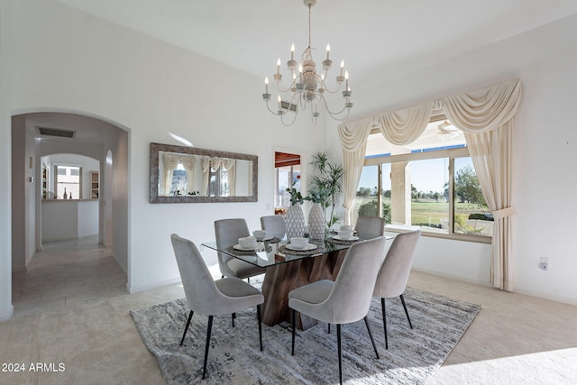 dining room with light colored carpet and a chandelier