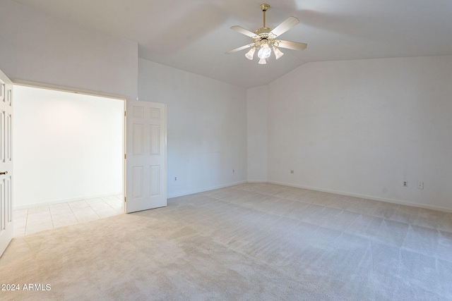 spare room featuring lofted ceiling, ceiling fan, and light carpet