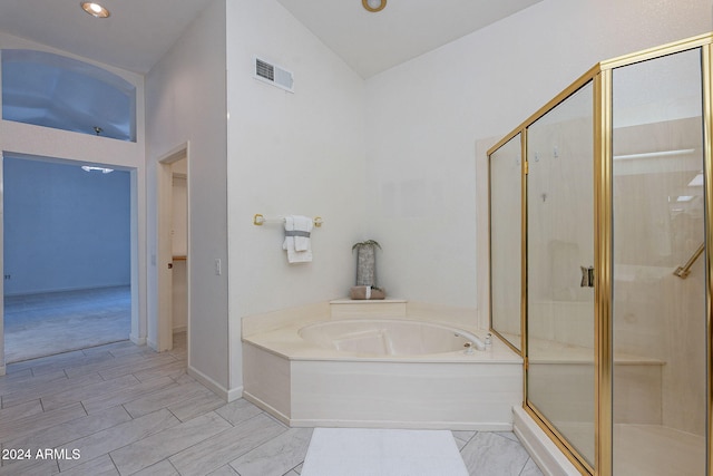 bathroom with independent shower and bath and lofted ceiling