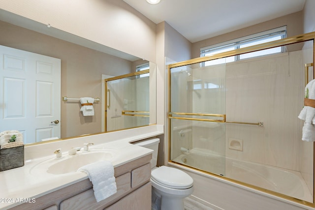 full bathroom featuring toilet, vanity, and bath / shower combo with glass door