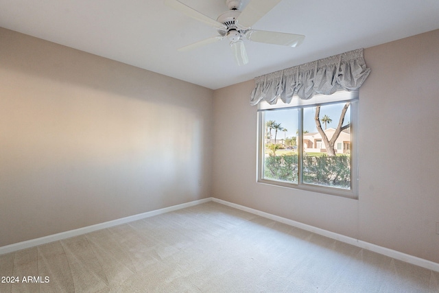 carpeted spare room with ceiling fan