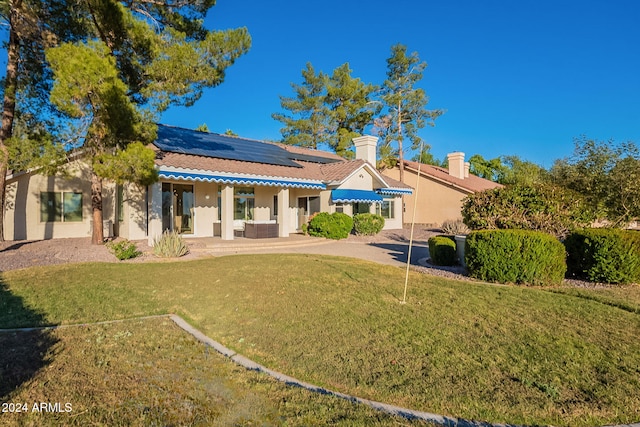 back of property featuring a patio, solar panels, and a lawn